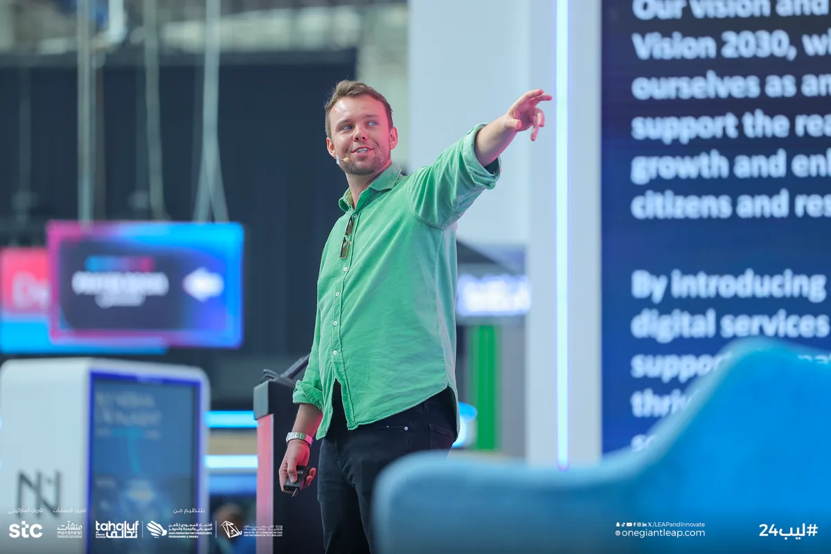 Aaron reaching towards the audience while speaking at LEAP 2024